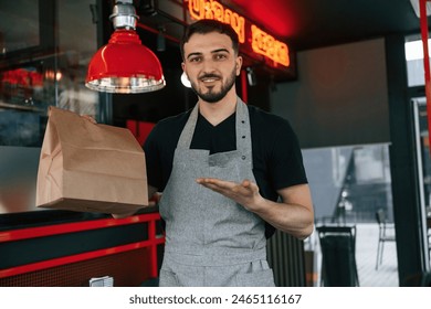 Order in package is ready. Man is serving delicious street food.