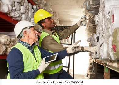 Order Picker With Tablet Pc And Young Warehouse Worker In Carpet Warehouse