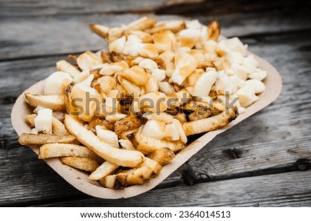 An order of poutine, a French Canadian dish of French fries, gravy, and cheese curds, at a stake street food stand.