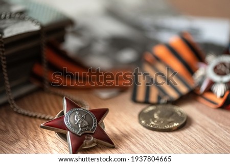 Order of Red Star on blurred background with St. George's ribbon and medals. 9 MAY greeting card. Transcription " Workers of all countries, unite USSR