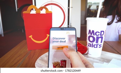 Ordering Mc Donalds Food Online In A McDonald Fastfood Restaurant With Smartphone In Bologna, Italy, Circa June 2020