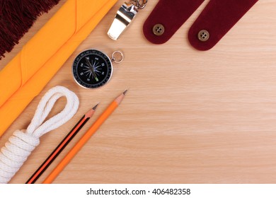 Orderliness white scout rope, scarf, whistle, pencil, compass and blank shoulder epaulette on wooden table. - Shutterstock ID 406482358
