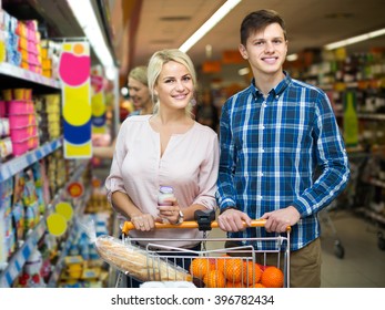 Ordinary american family choosing dairy products and smiling in hypermarket