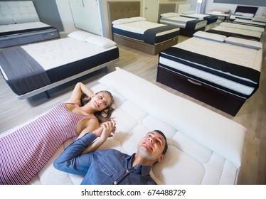 Ordinary Family Choosing Mattresses In The Store