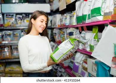 Ordinary Female Customer Buying Dry Food For Dogs In Pet Shop
