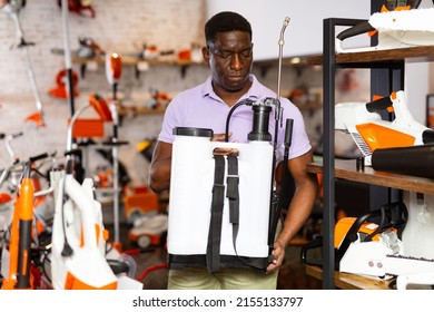 Ordinary Man Deciding On Best Garden Sprayer In Garden Equipment Shop