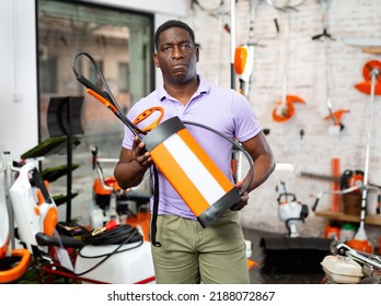 Ordinary Man Deciding On Best Garden Sprayer In Garden Equipment Shop