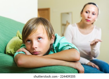 Ordinary Mother Scolding Depressed Teenager Son In Living Room At Home 