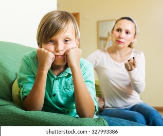 Ordinary Mother Scolding Sad Teenager Son In Living Room At Home
