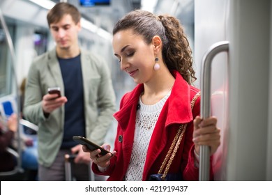 Ordinary passengers busy with smartphones in metro wagon 