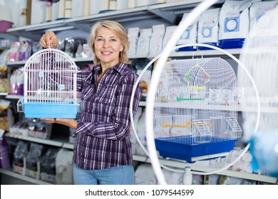 Ordinary Woman Buying Cage For Bird In Shop