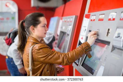 Ordinary Young Female Buying Ticket At Subway Station Machine
