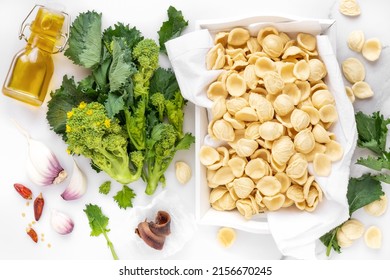 Orecchiette Con Cime Di Rapa Ingredients Typical Of Apulia Regional Cuisine - Homemade Fresh Pasta, Turnip Greens, Chilli Pepper, Garlic And Anchovy At The Background. Flat Lay, Overhead View