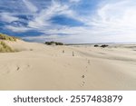 Oregon coast sand dunes with blue sky and wispy clouds, Newport Oregon