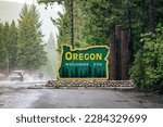 Oregon welcomes you sign at state line. US-HWY 199 Redwood Highway in rain.