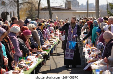 Orel, Russia, April 11, 2015: Traditional orthodox paschal ritual - priest blessing easter eggs and kulitches with holy water horizontal