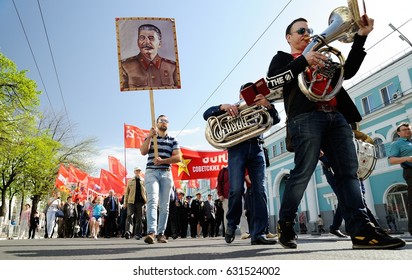 Orel, Russia - May 1, 2017: May demonstration. Trumpeters marching in front of crowd with Stalin portrait and red Communist flags