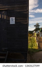 Orford, Suffolk/UK - October 21st 2018:  Man Reflecting On Brexit Fishing For Leave Sign On Locked Fishing Shed. 