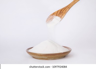 Organic Acacia Fiber Powder With Wooden Spoon Isolated On White Background.