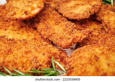 Organic Breaded Chicken Cutlet Served On A Plate With Rosemary Garnish