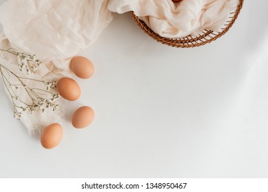 Organic brown eggs on a white surface.