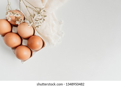 Organic brown eggs on a white surface.
