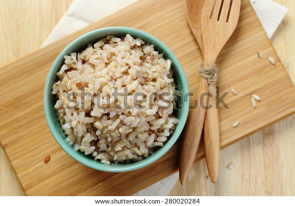Organic Brown\
Rice in the bowl on the wooden\
table