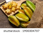 Organic carambola Asian fruit whole in a wicker basket and cut into a pine, carambola, grown on an organic farm on a rustic wooden table top, top view with space for writing