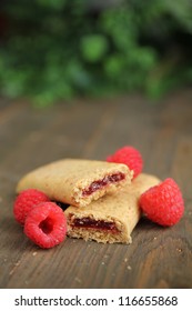 Organic Cereal Bar With Fruit Filling And Fresh Raspberry On A Wooden Table