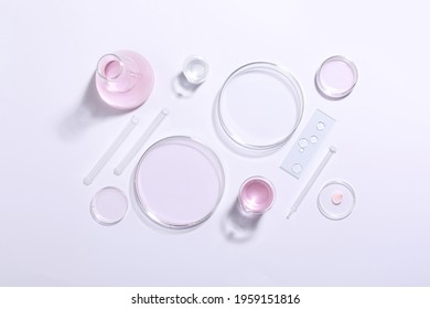 Organic cosmetic product and laboratory glassware on white background, top view