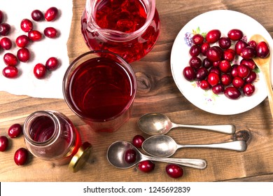 Organic Cranberries And Cranberry Juice With Cold Ice Cubes In A Glass On A Wooden Table