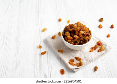 Organic Dried Raisins In A White Bowl, Side View. Space For Text.