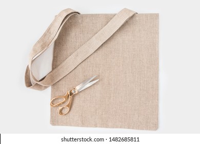 Organic Eco Shopping Bag With Tailor Scissors With Gold Handle Isolated On White Background, Top View. Design Mockup.