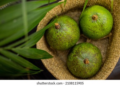 Organic farm avocado in straw basket on wooden table closeup. Fresh ripe green exotic fruits full of healthy nutriment vegetarian eating. Three tropical edible plant with twig for guacamole cooking - Shutterstock ID 2108115905