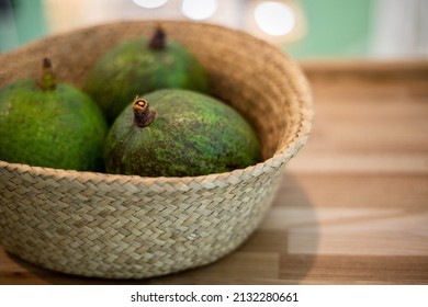 Organic farm avocado in straw basket on wooden table closeup. Fresh ripe green exotic fruits full of healthy nutriment vegetarian eating. Three tropical edible plant with twig for guacamole cooking - Shutterstock ID 2132280661