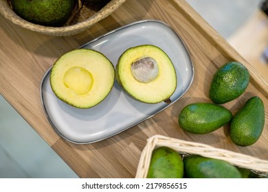 Organic farm avocado in straw basket on wooden table closeup. Fresh ripe green exotic fruits full of healthy nutriment vegetarian eating. Three tropical edible plant with twig for guacamole cooking - Shutterstock ID 2179856515