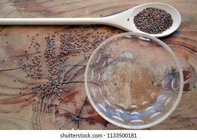 Organic Flaxseed Gel Recipe For Natural Hair Care. Eco Styling And Moisturizing. With Wooden Spoon, Wooden Background, Glass Bowl, And Flax Seeds.