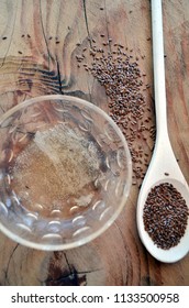 Organic Flaxseed Gel Recipe For Natural Hair Care. Eco Styling And Moisturizing. With Wooden Spoon, Wooden Background, Glass Bowl, And Flax Seeds. Vertical From Above.