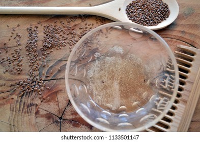 Organic Flaxseed Gel Recipe For Natural Hair Care. Eco Styling And Moisturizing, Rich In Omega3. With Wooden Spoon, Wooden Background, Wooden Comb, Glass Bowl, And Flax Seeds. Horizontal From Above.