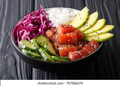 Organic food: tuna poke bowl with rice, fresh cucumbers, red cabbage and avocado close-up on the table. horizontal - Shutterstock ID 707586379
