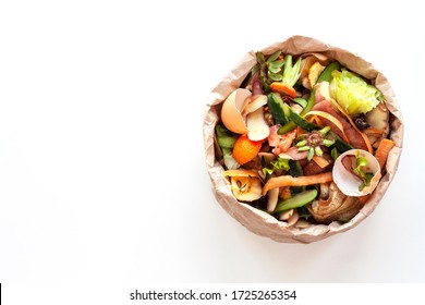 Organic food waste in paper bag on white kitchen table. Vegetable peelings and food leftovers ready to compost. Environmentally responsible behavior, ecological, recycling waste concept. Copy space. - Powered by Shutterstock