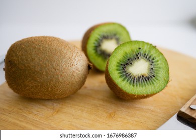 Organic fresh kiwi fruit on an old wooden cutting board and utensils. rustic style. Close up - Powered by Shutterstock