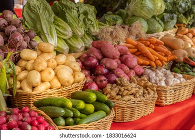 Organic fresh produce at the weekly farmers market downtown. A variety of locally grown yellow potatoes, red potatoes, ginger, cucumbers, carrots, butternut squash, lettuce, and greens on display. - Powered by Shutterstock