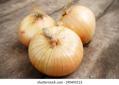Organic fresh ripe onion on wooden background
