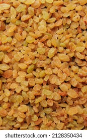 Organic golden raisins texture. Close up food background. Top view.