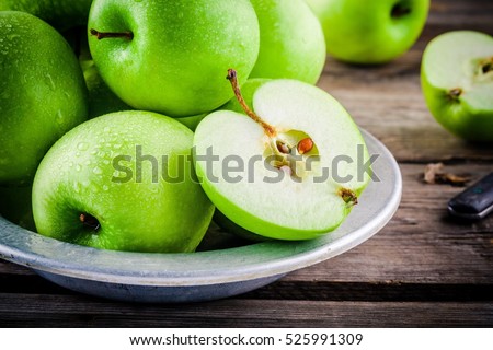 organic green juicy apples on a rustic wooden background