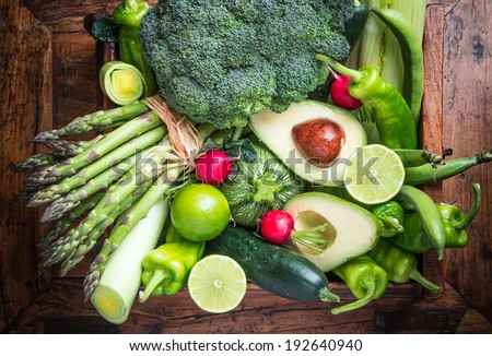 Organic green vegetables and fruits on dark wooden background.Healthy food.