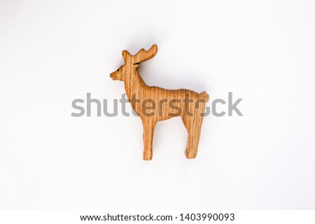 Organic hand made wooden deer toy isolated on white background. Environment friendly natural stuff. Ecological lifestyle. Baby care and childhood concept. Trendy element for design mock-up.