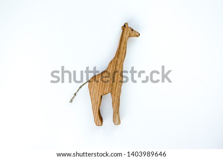 Organic hand made wooden giraffe toy isolated on white background. Environment friendly natural stuff. Ecological lifestyle. Baby care and childhood concept. Trendy element for design mock-up.