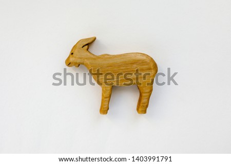 Organic hand made wooden goat toy isolated on white background. Environment friendly natural stuff. Ecological lifestyle. Baby care and childhood concept. Trendy element for design mock-up.